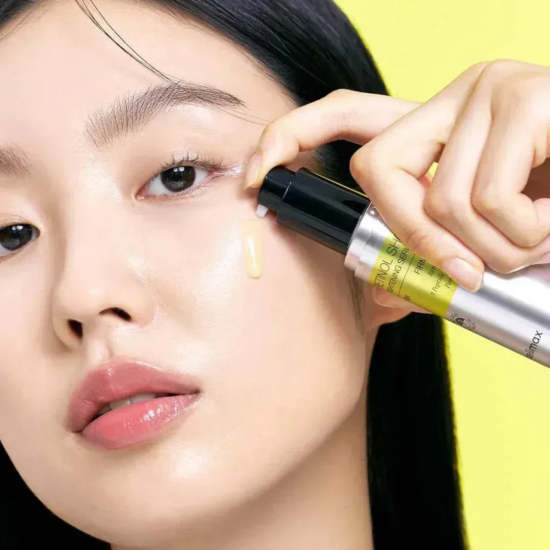 A woman applying a Celimax serum under her eye